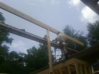 Carpenter setting a ridge beam over a new addition frame — Ice Dam Removal by Roofing Brothers in White Bird