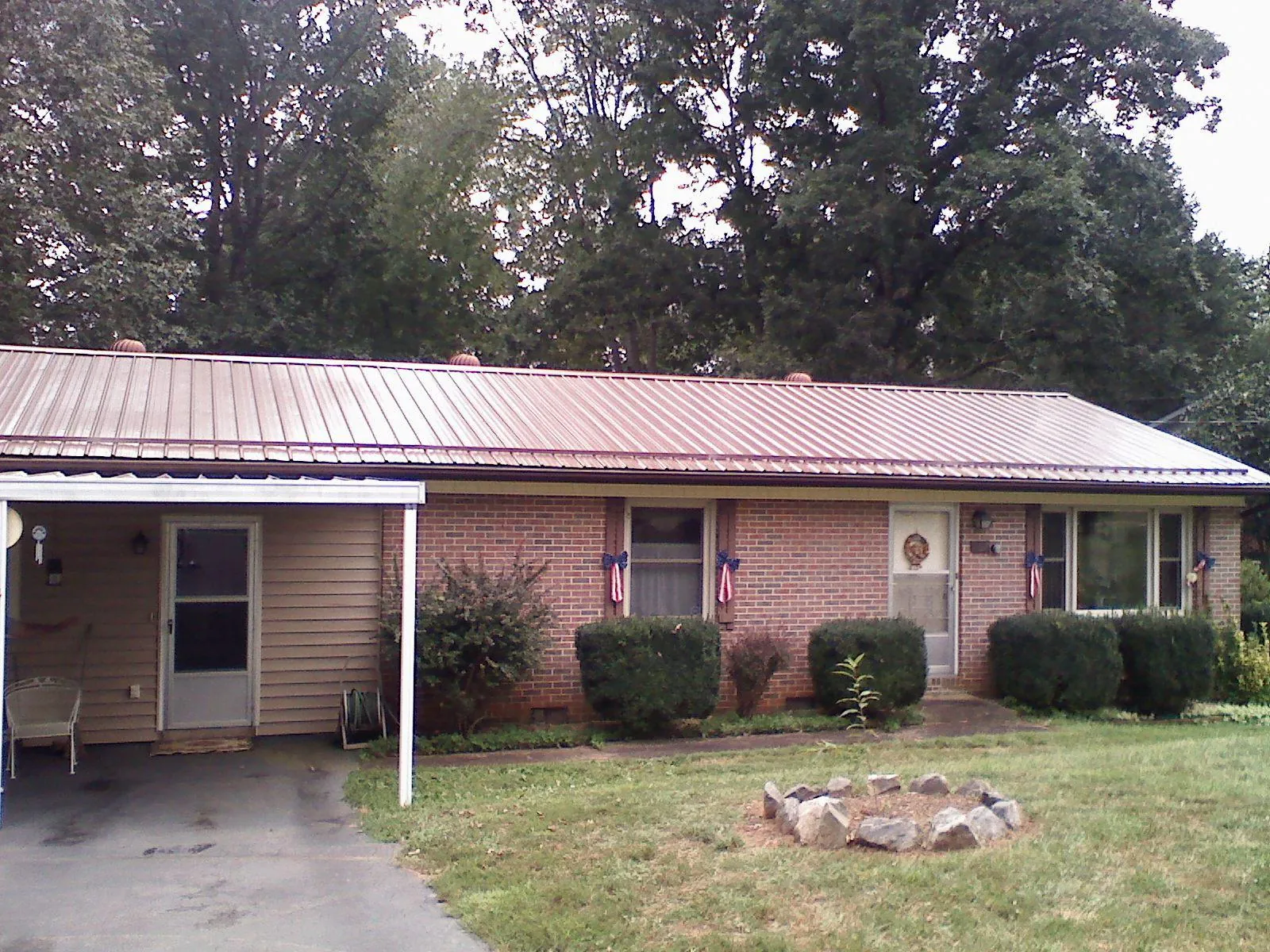 Bronze metal roof and carport on a brick ranch home — Roof Repair work by our crew in White Bird